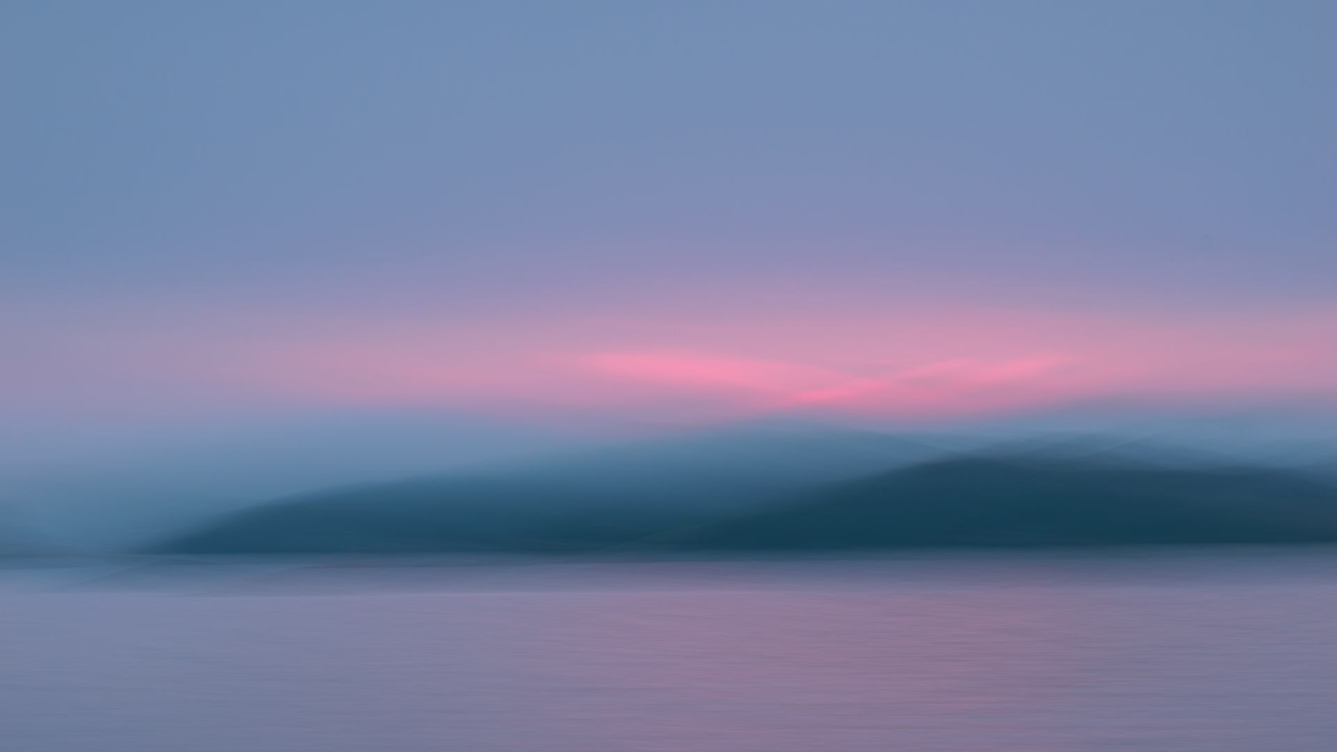 Pastel dusk over distant hills and water